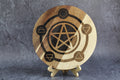 Wooden circular cutting board with pentagram design on a gray background