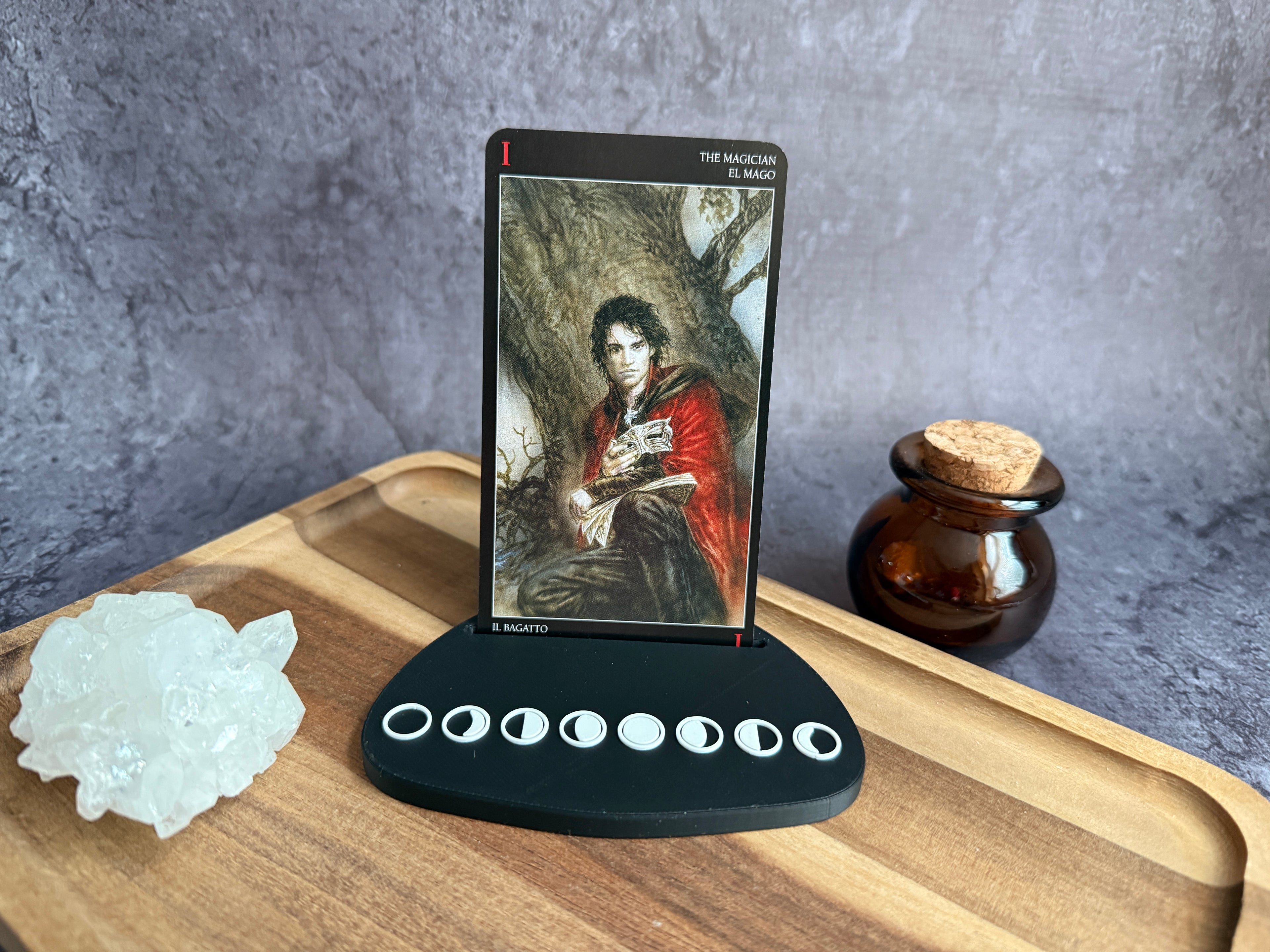 Tarot card holder with a card in it with character illustration all on a wooden surface