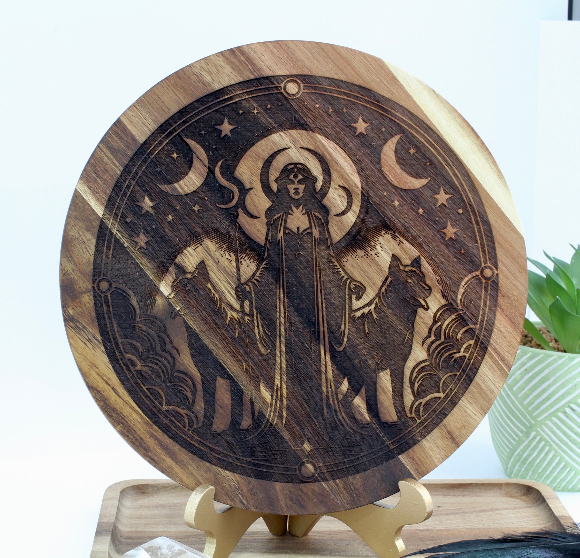 Wooden circular decoration with engraved design of Hecate and wolf on a stand.