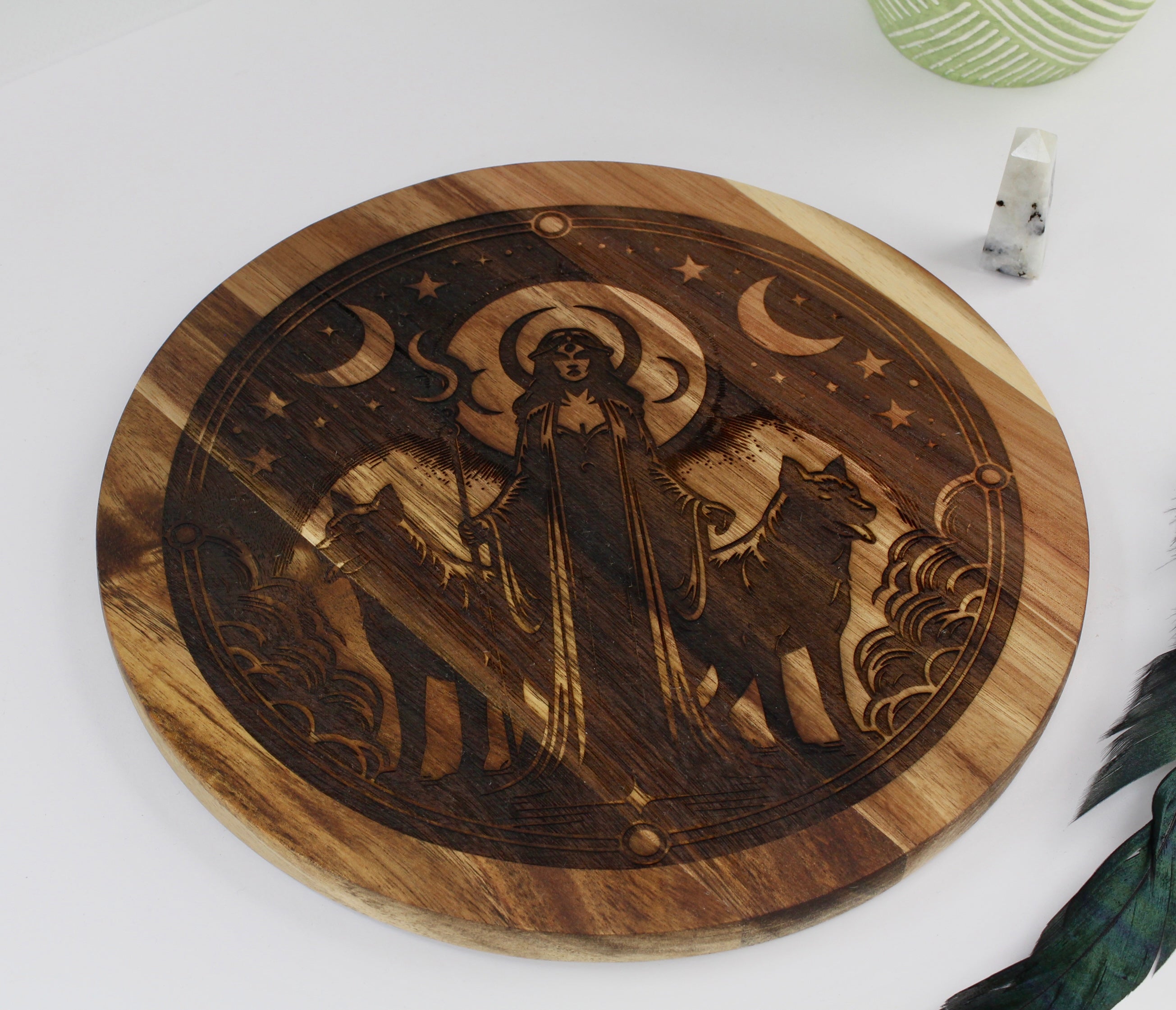 Wooden cutting board with engraved design of Hecate with a wolf on a white surface